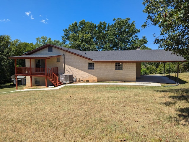 rear view of property with a yard, central AC, and a carport