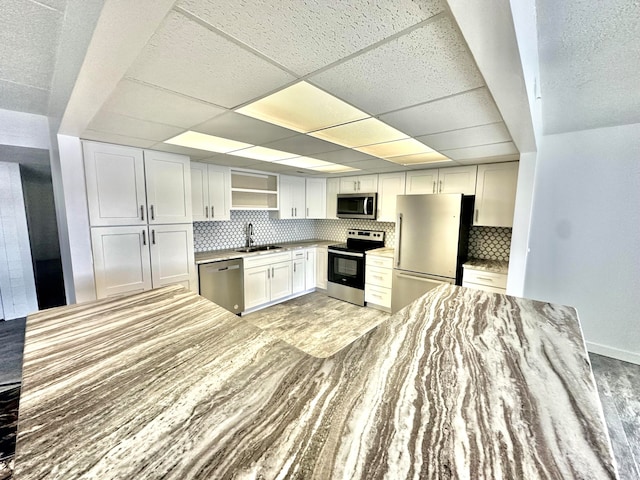 kitchen featuring white cabinets, stainless steel appliances, sink, and decorative backsplash