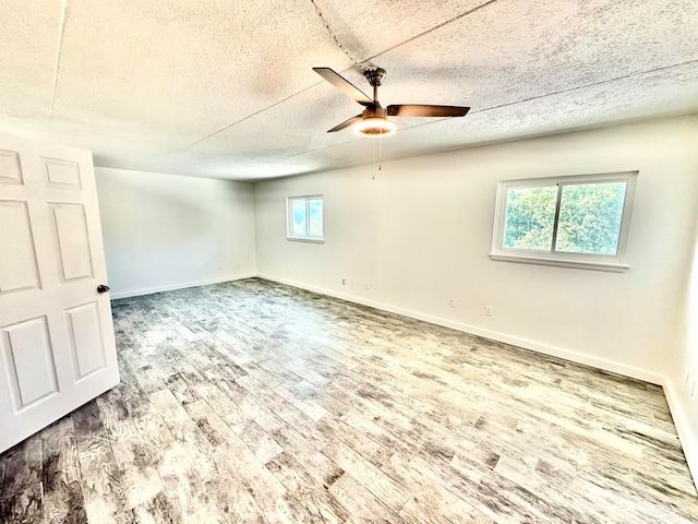 unfurnished room featuring a textured ceiling, wood-type flooring, and ceiling fan