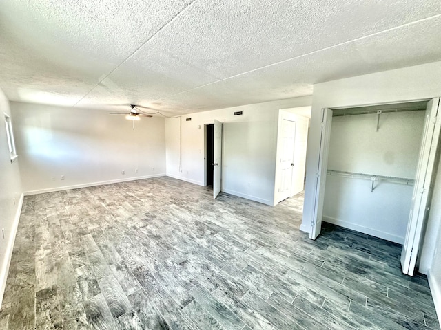 unfurnished bedroom featuring a textured ceiling, ceiling fan, and wood-type flooring