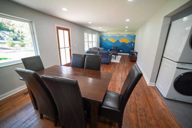 dining area with stacked washer / drying machine and dark wood-type flooring