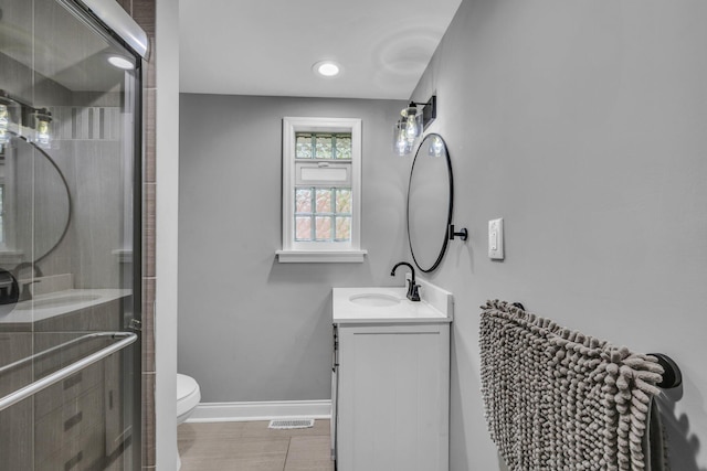 bathroom with tile patterned flooring, vanity, toilet, and walk in shower