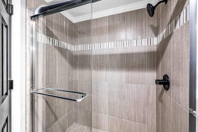 bathroom featuring a shower with shower door and ornamental molding