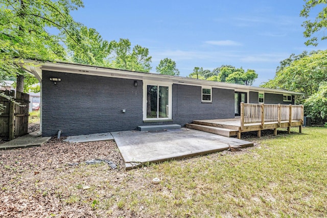 rear view of property featuring a yard, a deck, central AC unit, and a patio area