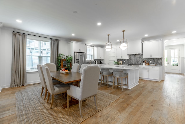 dining area with crown molding and light wood-type flooring