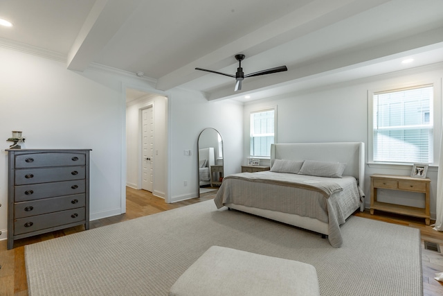 bedroom with crown molding, ceiling fan, light wood-type flooring, and beam ceiling