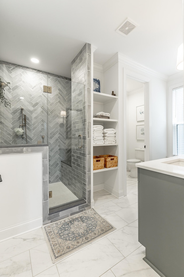 bathroom featuring crown molding, vanity, toilet, and an enclosed shower