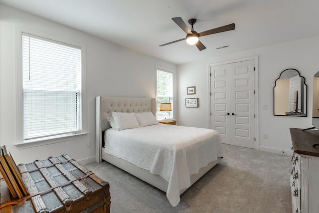 bedroom featuring ceiling fan, a closet, and light carpet