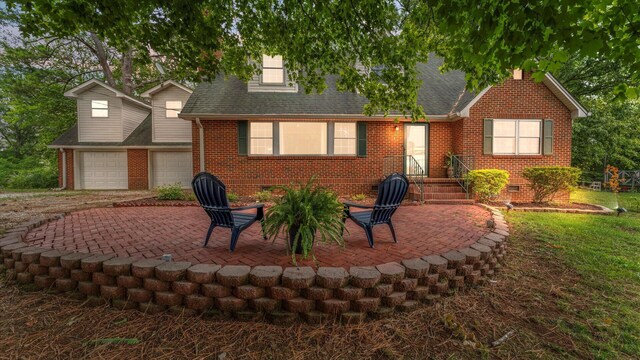 back of house with a garage and a patio