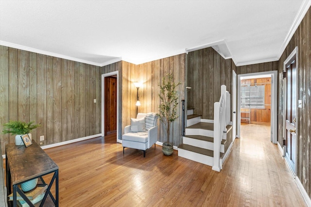 entryway with hardwood / wood-style floors, a textured ceiling, wood walls, and ornamental molding