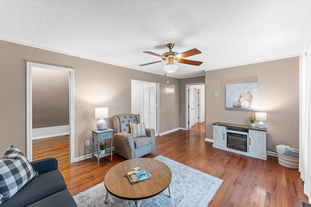 living room with a textured ceiling, ceiling fan, and hardwood / wood-style floors