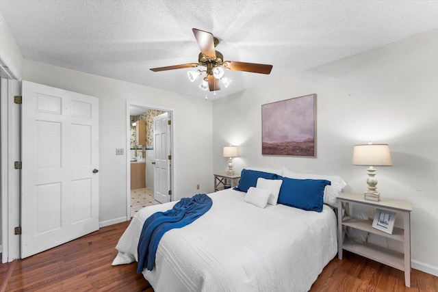 bedroom featuring a textured ceiling, ceiling fan, dark hardwood / wood-style floors, and ensuite bath