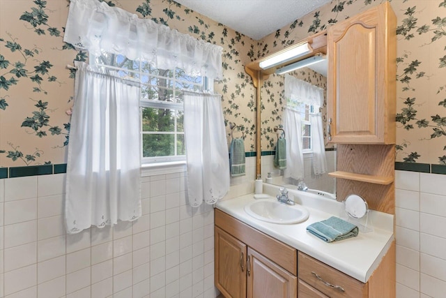 bathroom featuring tile walls, a textured ceiling, and vanity