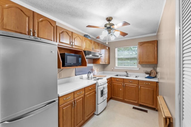 kitchen with a textured ceiling, stainless steel refrigerator, white range oven, sink, and ceiling fan