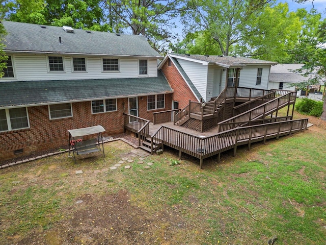 rear view of property featuring a lawn and a deck