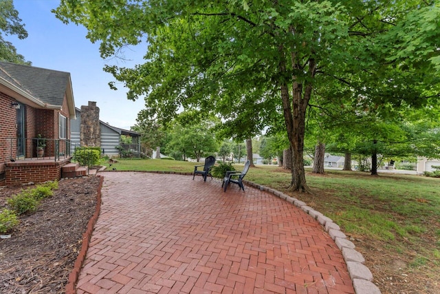 view of home's community with a lawn and a patio area