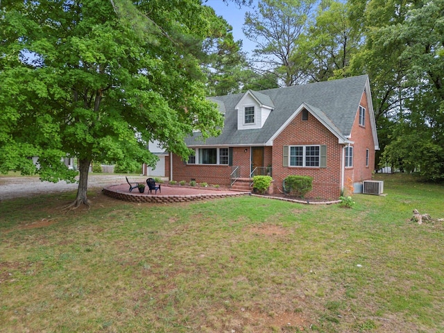 cape cod house with central air condition unit, a front yard, and a patio