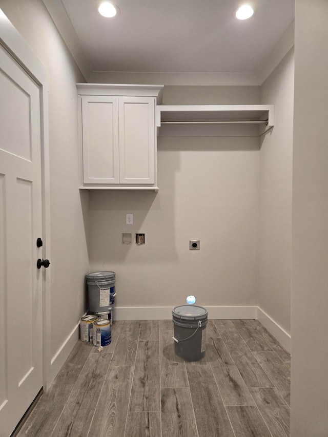 washroom with electric dryer hookup, cabinets, washer hookup, ornamental molding, and light wood-type flooring