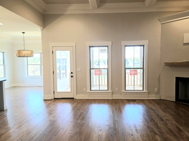 unfurnished living room featuring crown molding, plenty of natural light, and dark hardwood / wood-style flooring