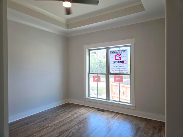 spare room featuring ceiling fan, dark hardwood / wood-style flooring, and a raised ceiling