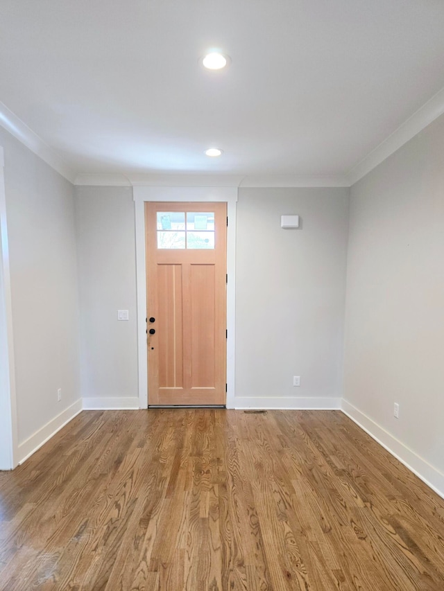 foyer featuring ornamental molding and light wood-type flooring