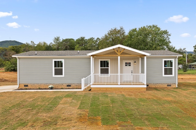 manufactured / mobile home featuring covered porch and a front yard