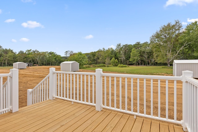 wooden terrace featuring a yard and a storage unit