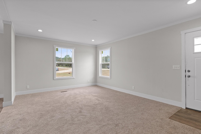 entrance foyer featuring ornamental molding and light colored carpet