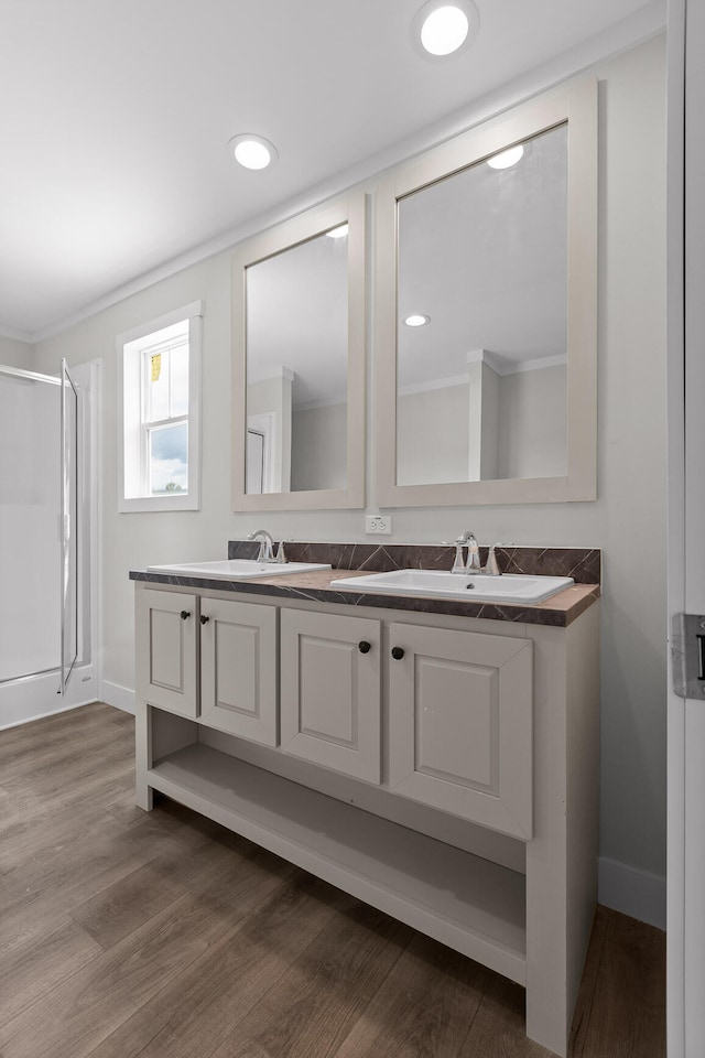 bathroom with vanity, hardwood / wood-style floors, and a shower with door