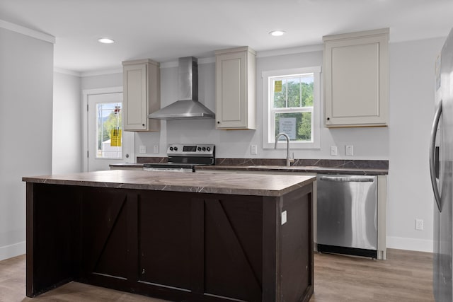 kitchen with sink, a center island with sink, light hardwood / wood-style flooring, wall chimney range hood, and stainless steel appliances