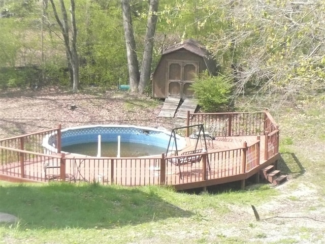 view of pool featuring a deck and a shed