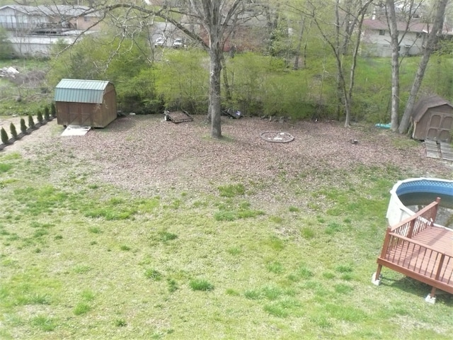 view of yard featuring a wooden deck and a storage shed