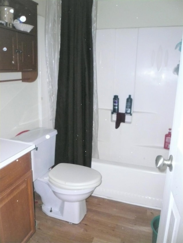 full bathroom featuring wood-type flooring, toilet, shower / tub combo, and vanity