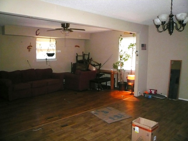 living room featuring ceiling fan with notable chandelier and dark hardwood / wood-style flooring