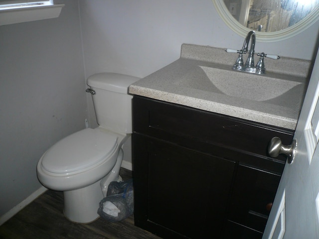 bathroom with vanity, toilet, and wood-type flooring