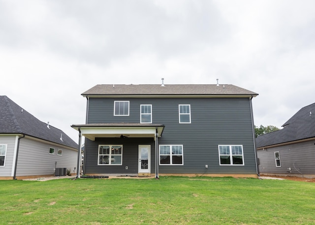 rear view of property with ceiling fan, a yard, and central air condition unit