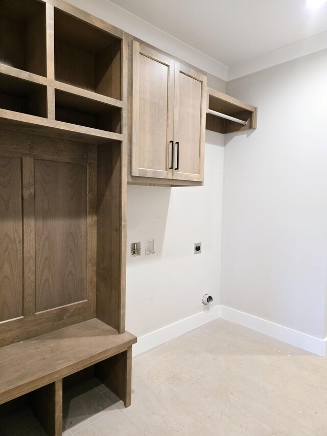 clothes washing area with cabinets, crown molding, and hookup for an electric dryer