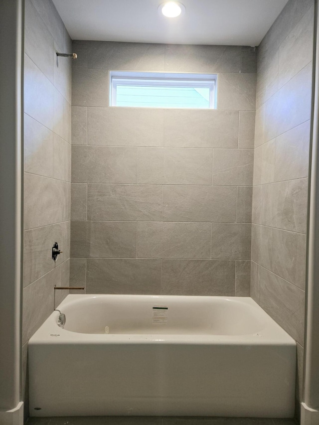 bathroom featuring tiled shower / bath combo and a wealth of natural light