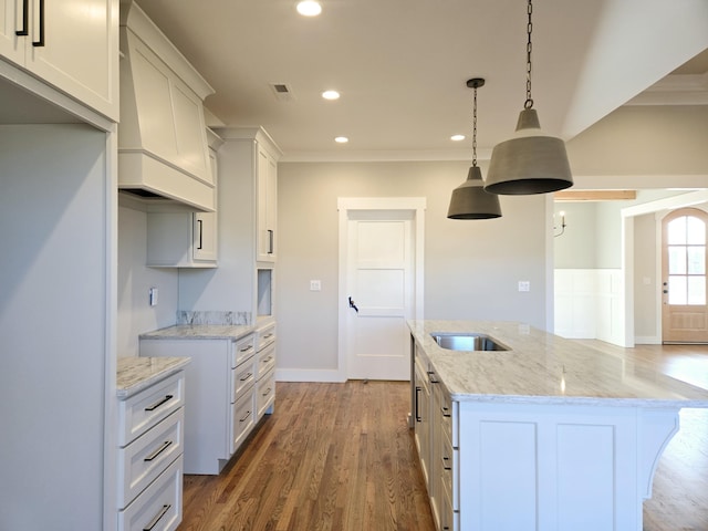 kitchen with white cabinetry, light stone countertops, and hanging light fixtures