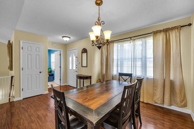 dining space with dark hardwood / wood-style flooring, a notable chandelier, and a textured ceiling