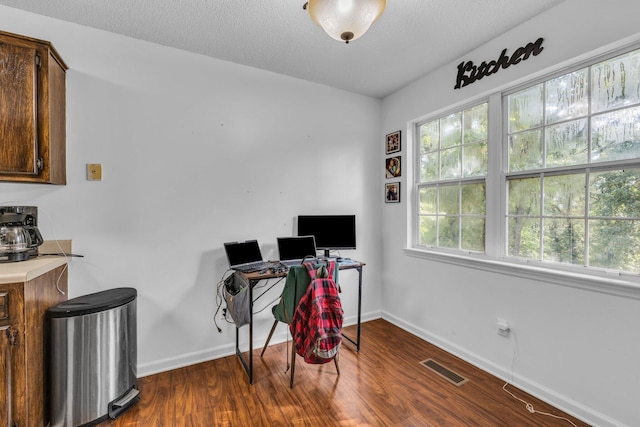 home office featuring dark wood-type flooring and a textured ceiling