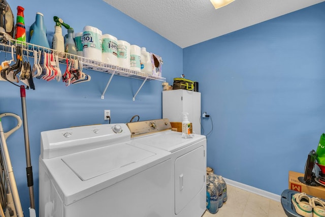 washroom featuring a textured ceiling and washer and clothes dryer