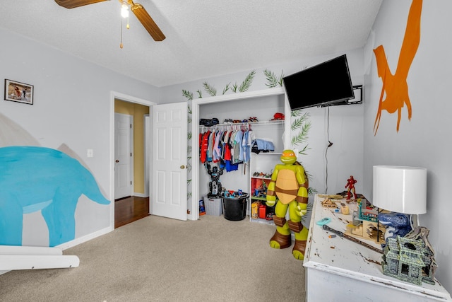 carpeted bedroom with a closet, ceiling fan, and a textured ceiling