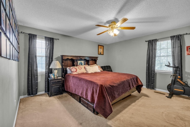 carpeted bedroom featuring a textured ceiling and ceiling fan