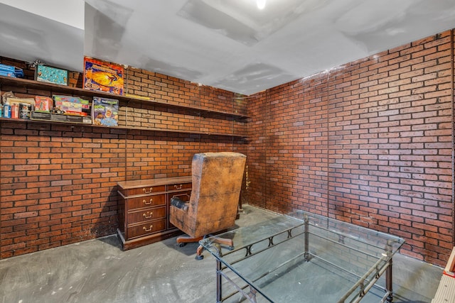 unfurnished office featuring brick wall and concrete flooring