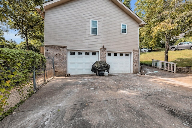 view of property exterior with a garage and a lawn