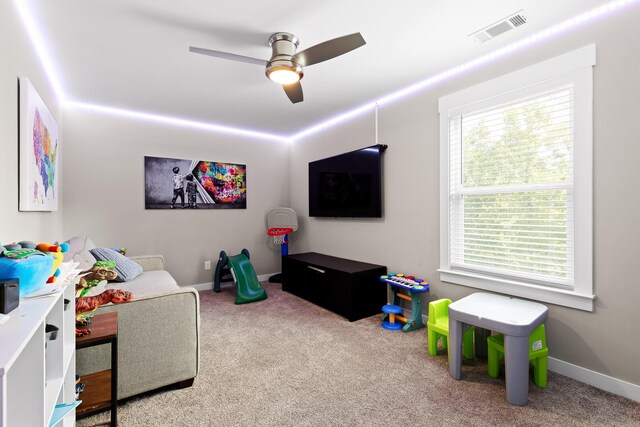 recreation room featuring light colored carpet and ceiling fan