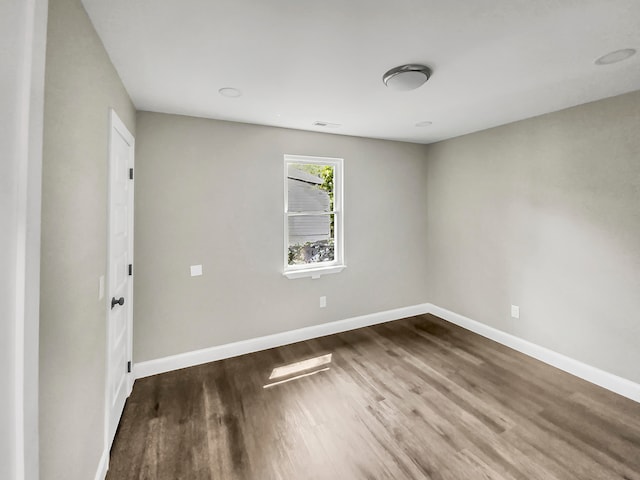 empty room with dark hardwood / wood-style flooring