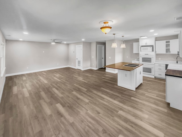 kitchen featuring hardwood / wood-style flooring, white appliances, white cabinetry, ceiling fan, and a kitchen island