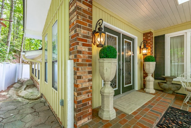 view of exterior entry featuring covered porch